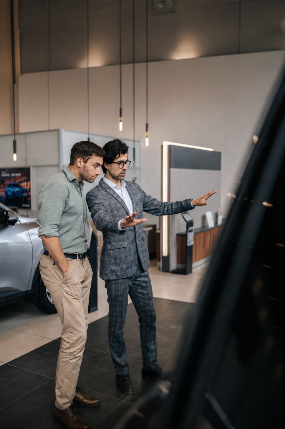 Un consulente mostra una vettura a un cliente nello showroom